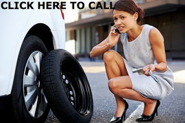 North Bay Towing Service. This is a photo of a lady looking at a temporary spare tire and on the phone calling for roadside assistance.